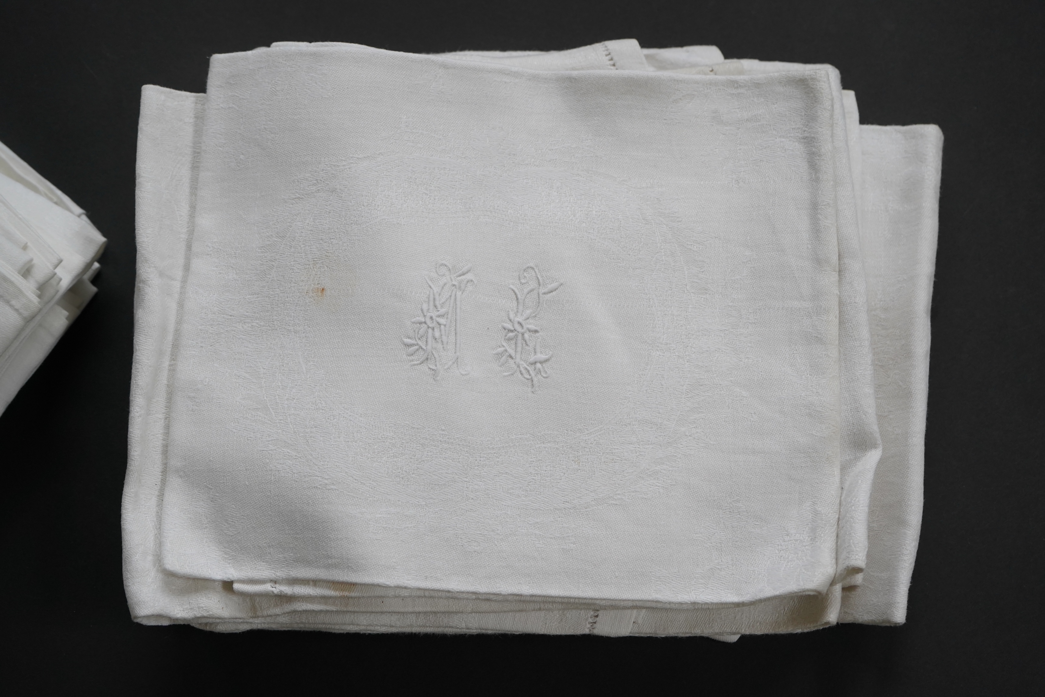 A set of fifteen large 19th century monogrammed damask dinner napkins and set of eight similar sized monogrammed damask dinner napkins, the larger set designed with a wide classical scrolling floral border and a simple d